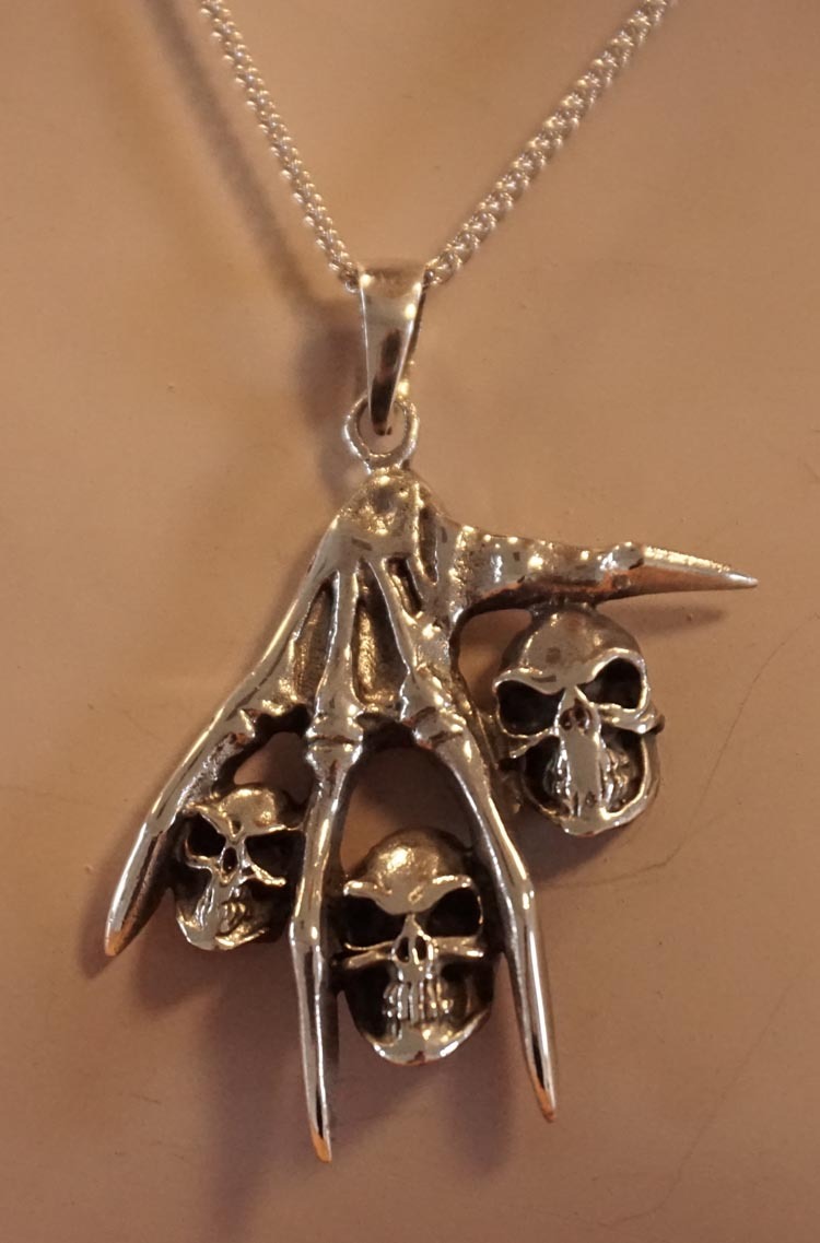 Zilveren hanger  " Skelet hand met doodskoppen "